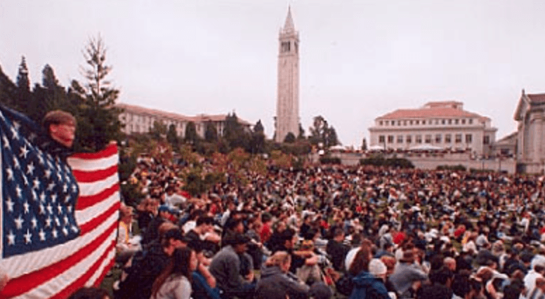 Campus rally at UC Berkeley with American flag and Campanile
